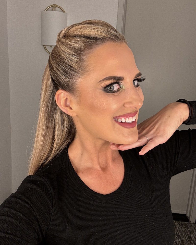Amy Hanson of Ballroom by Amy smiling, hair swept back, in a black top