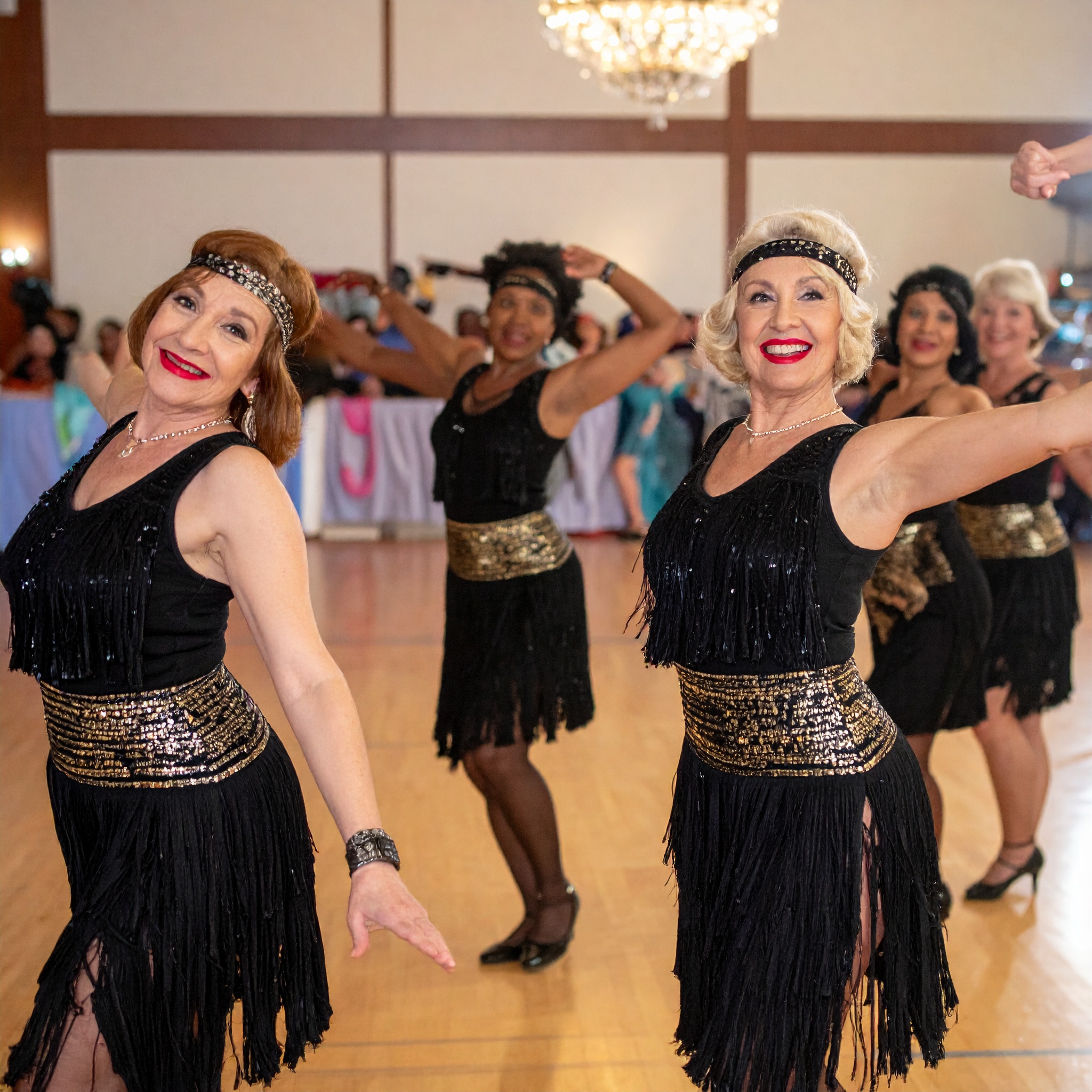 Illustration of a ladies formation team in matching black and gold flapper dresses and headbands dancing together on a ballroom floor